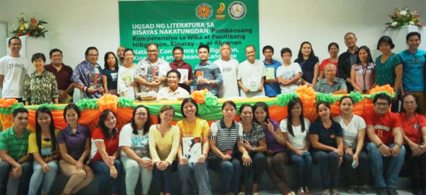 Si Sir Leo (sa tunga) kaimaw ang mga manunulat kag komunidad kang mga manunudlo kag manugbasa sa Gabii kang mga Manunulat kang Bisayas Nakatundan, Dis.1, 2014, West Visayas State University, Lapaz, Iloilo. Litrato halin sa KWF. 